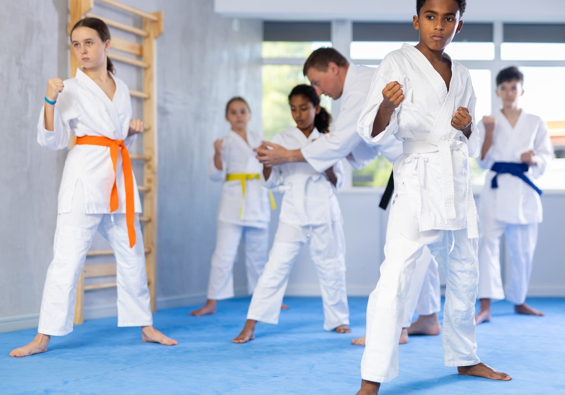 Group of karate kids practicing karate technique in gym..